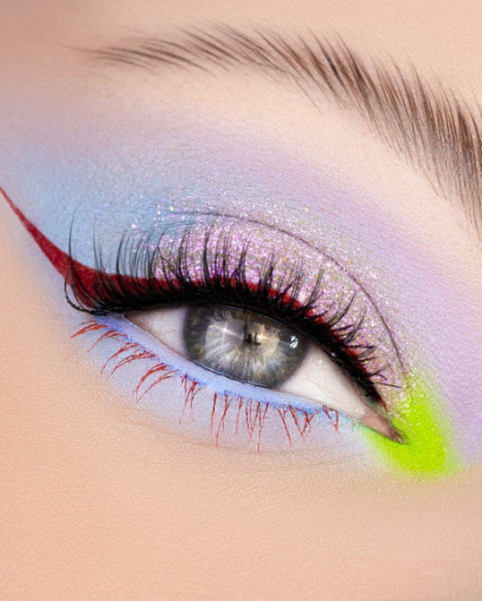 Holographic Duochrome eyeshadow. A shimmering, multi-dimensional makeup product featuring colour shifting pigments that transition between hues of purple and pink with a rainbow sparkle. Radiant, prismatic effect.
