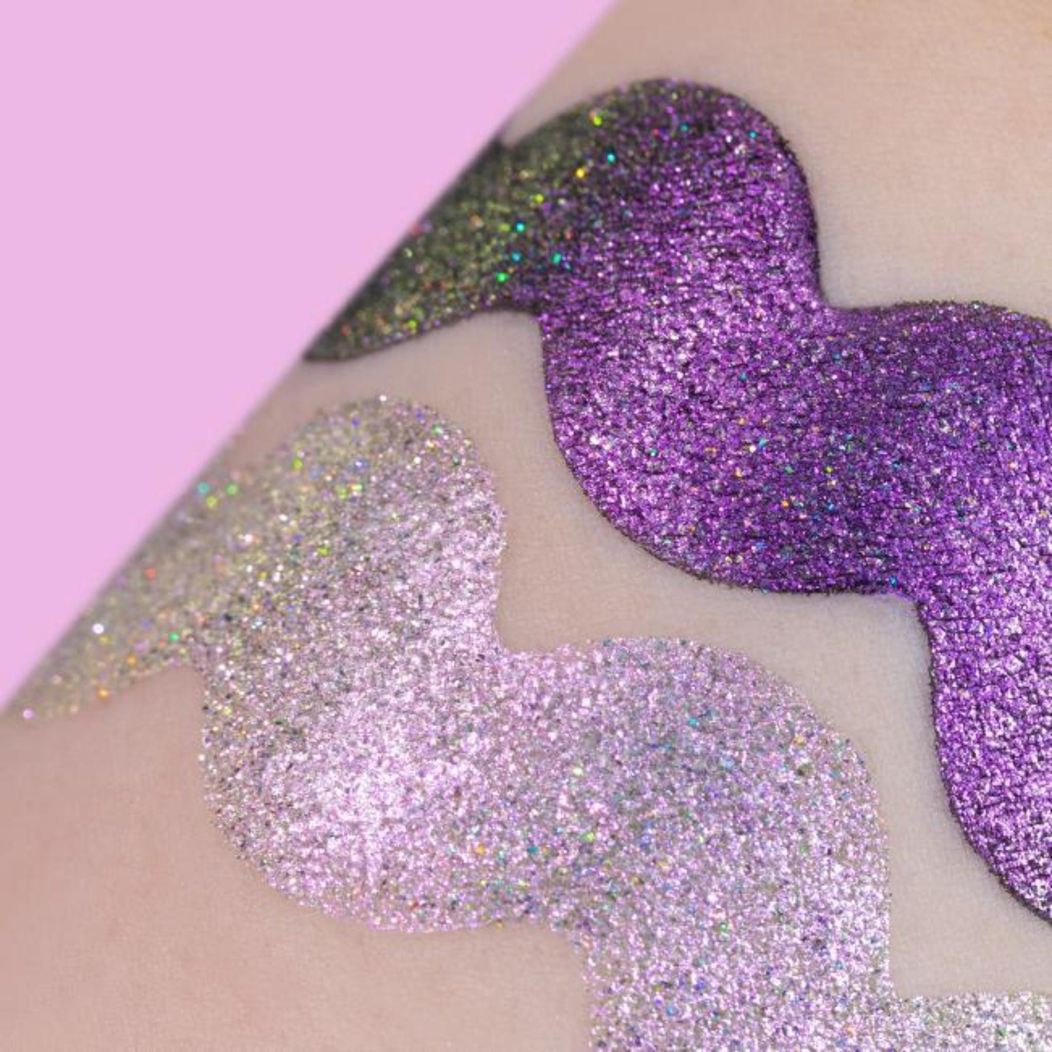 Holographic Duochrome eyeshadow. A shimmering, multi-dimensional makeup product featuring colour shifting pigments that transition between hues of purple and pink with a rainbow sparkle. Radiant, prismatic effect.